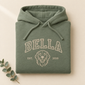 Salbeigrüner Hoodie mit gesticktem College-Schriftzug BELLA, Hunde-Linienporträt und EST. 2019