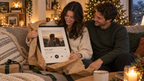 Paar packt das Song-Poster unterm Weihnachtsbaum aus