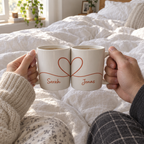 Pärchen-Tassen mit Herz im Bett am Morgen